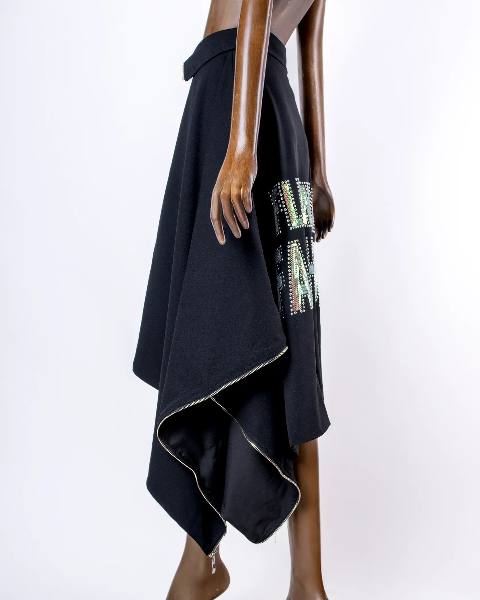Maniquí usando Capa Falda transformable negra 'fluent in fashion' de In-Diferente Fashion, mostrando su uso como falda vista lateral