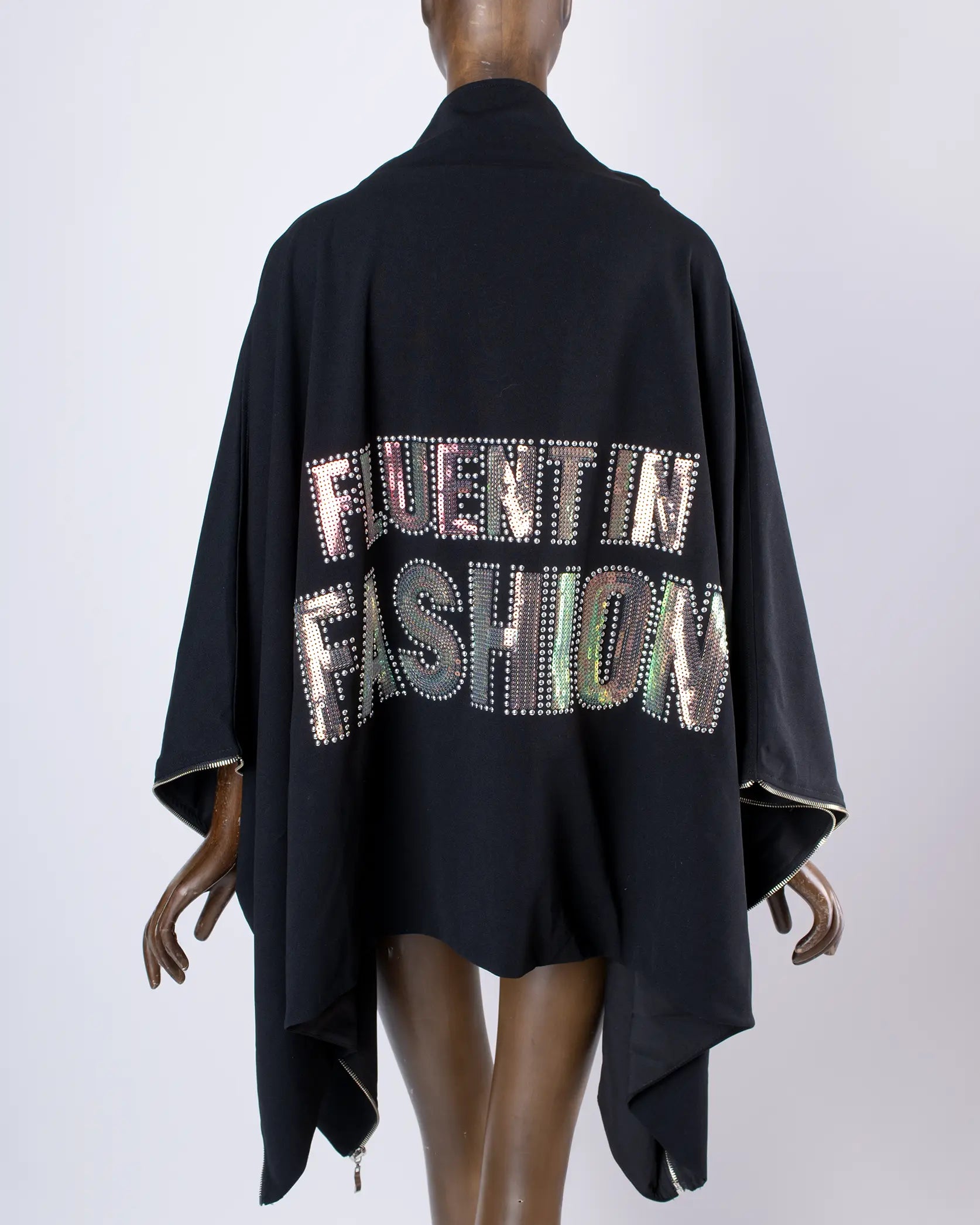 Maniquí usando Capa Falda transformable negra 'fluent in fashion' de In-Diferente Fashion, mostrando su uso como capa vista trasera