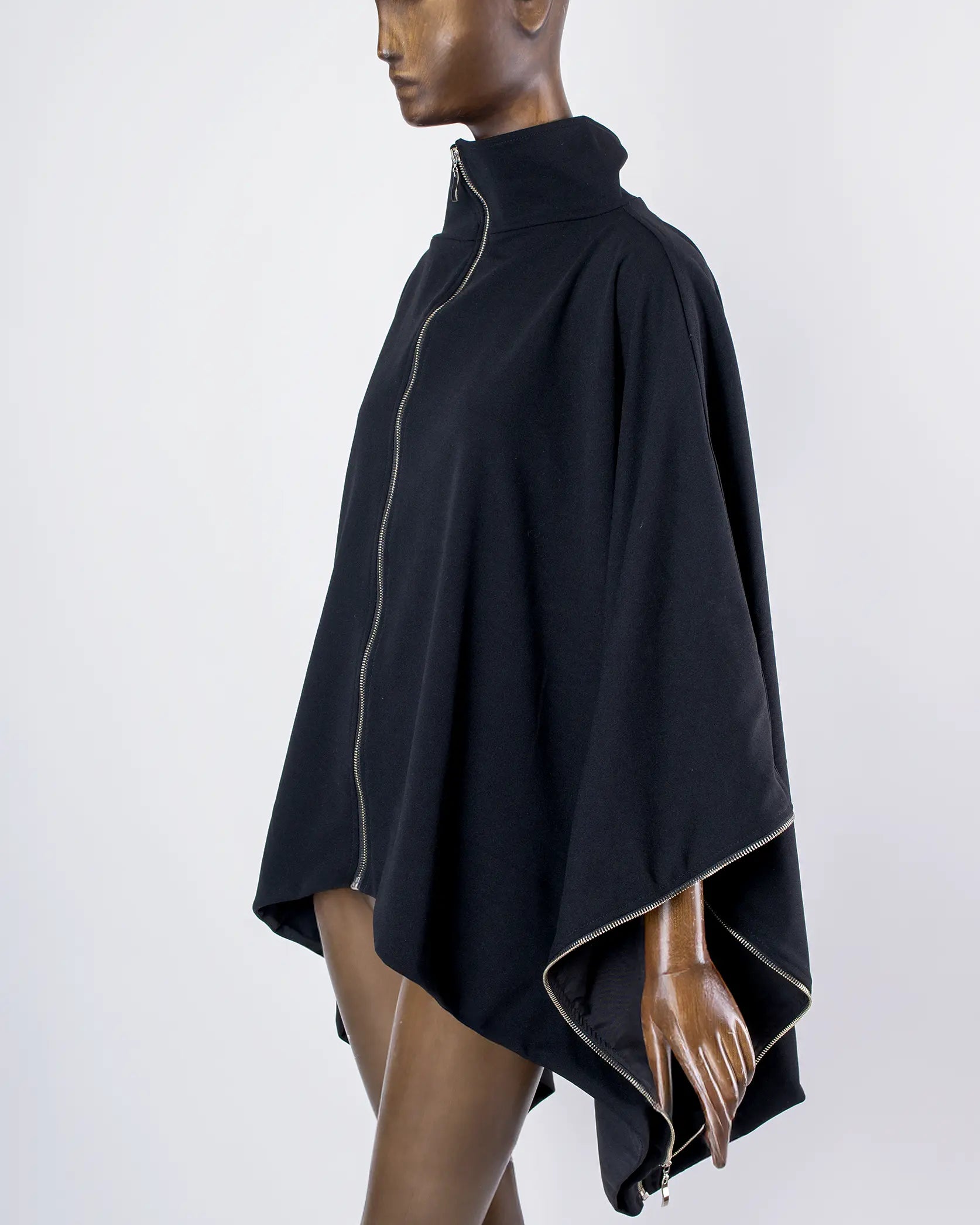 Maniquí usando Capa Falda transformable negra de In-Diferente Fashion, mostrando su uso como capa vista lateral