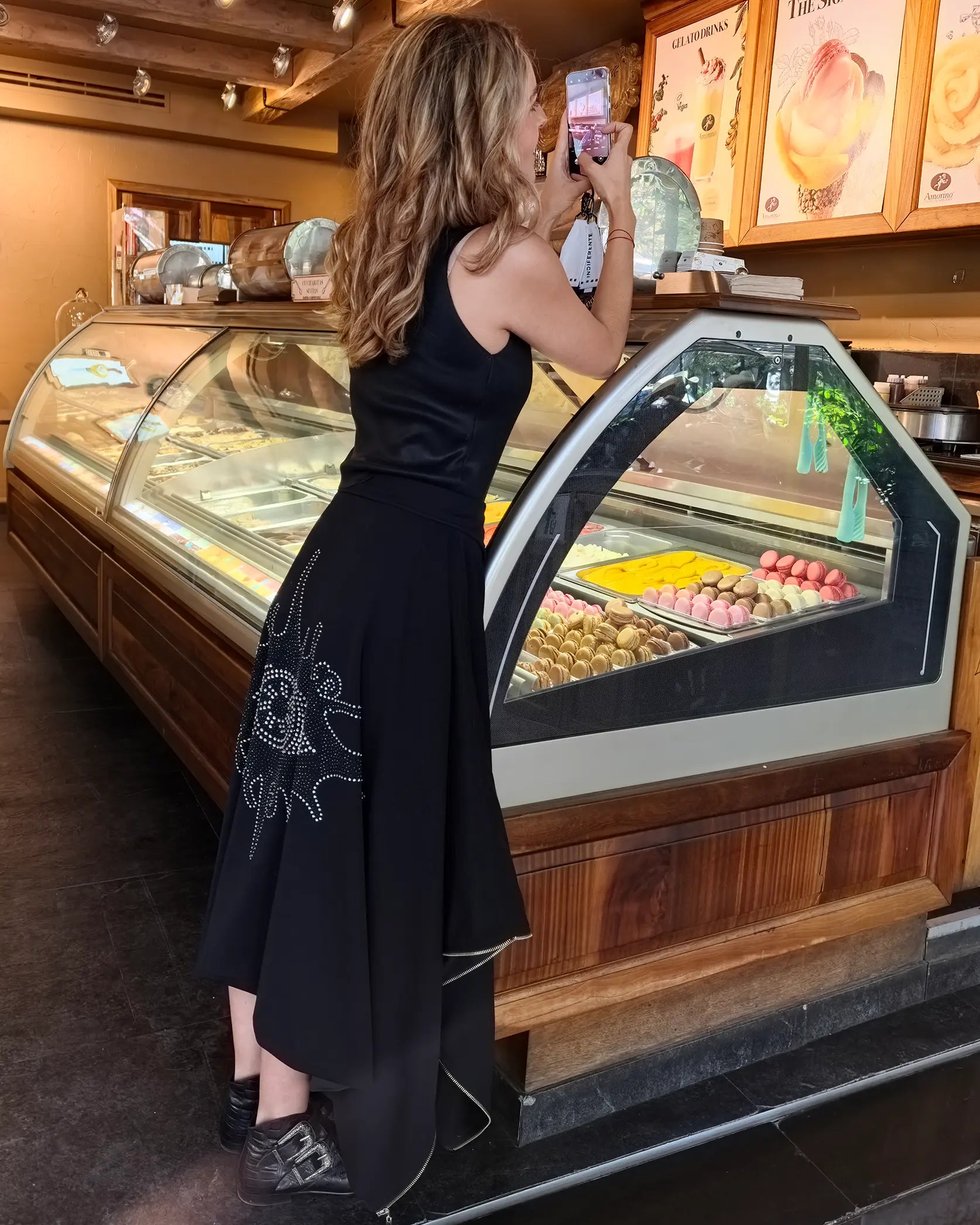Modelo usando Capa Falda transformable negra 'Ojo de Cristales' de In-Diferente Fashion, con cristales brillantes en la espalda, mostrando su uso como falda vista lateral