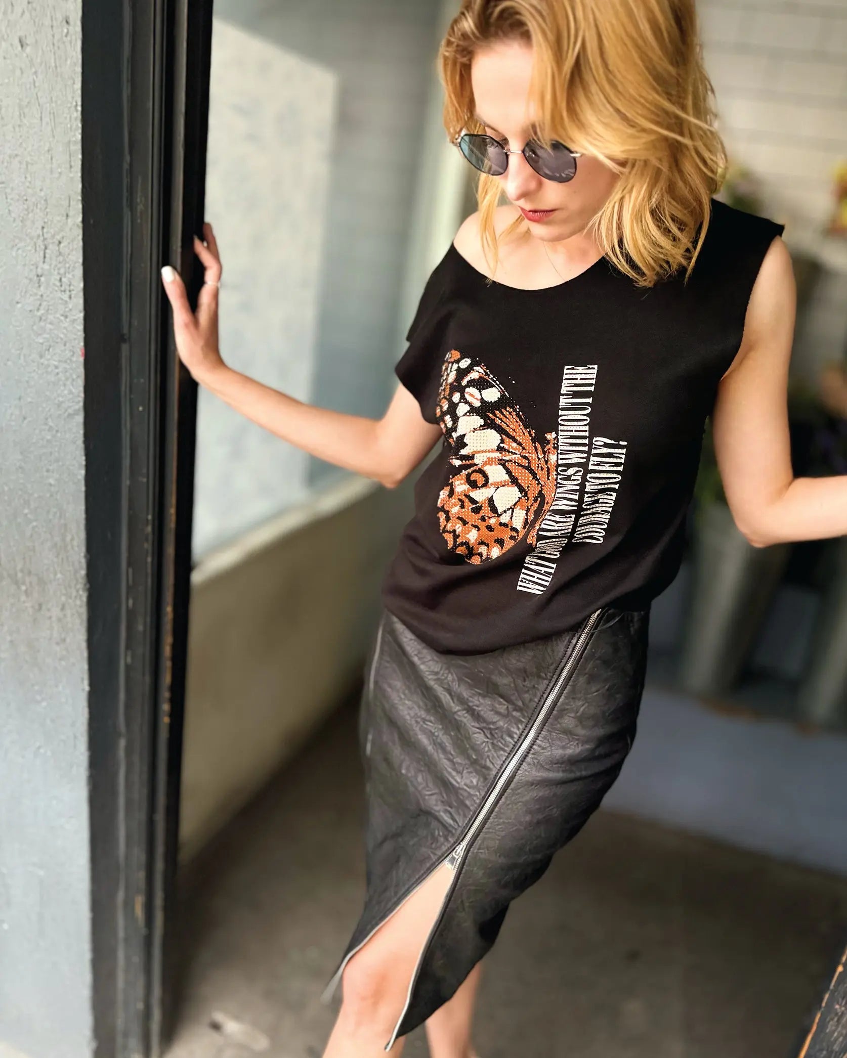Playera In-Diferente Fashion con mariposa Monarca y frase What good are wings without the courage to fly, decorada con pedrería.